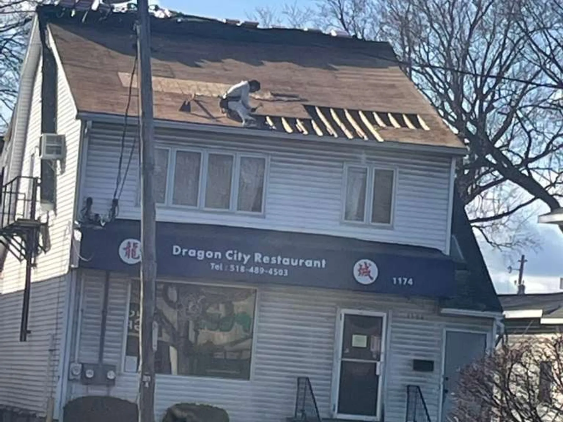 Roofer documenting hail damage on a shingle roof for a carrier report