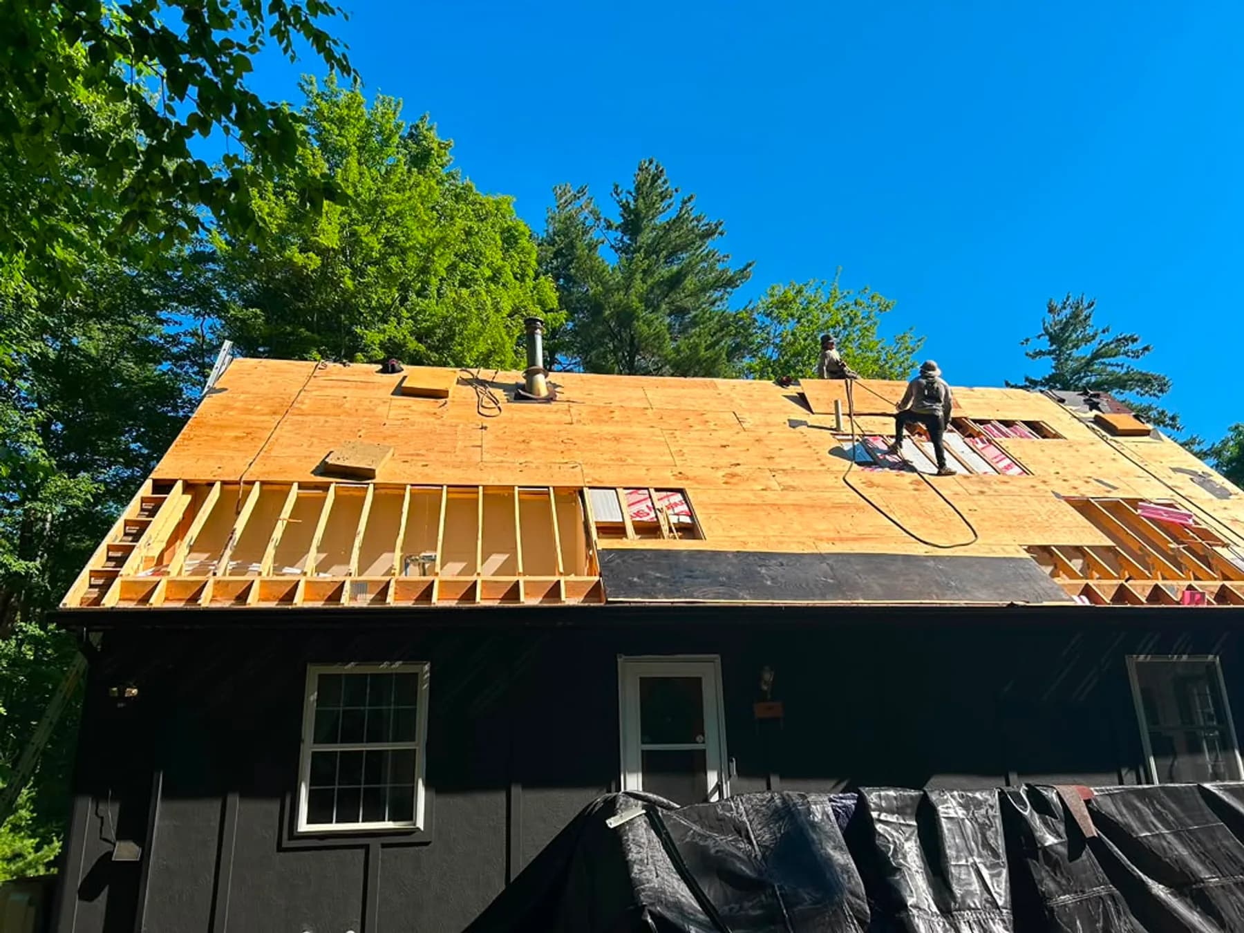 Newly installed asphalt shingle roof with flashing around a chimney