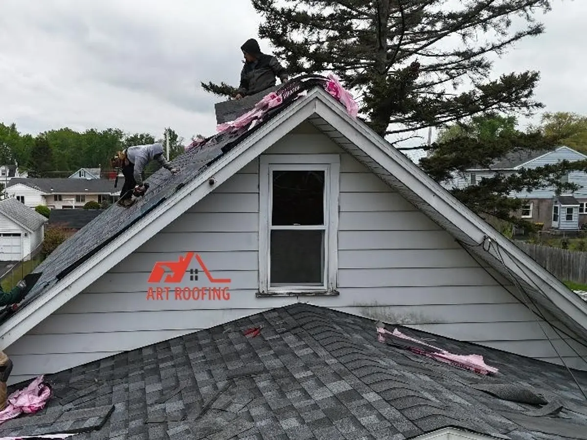 Roofer sealing a pipe boot flashing on a finished shingle roof
