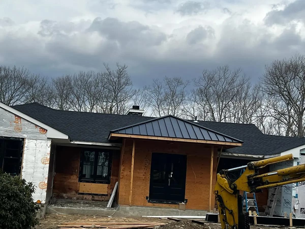 Completed black standing seam metal roof on a modern single-storey home