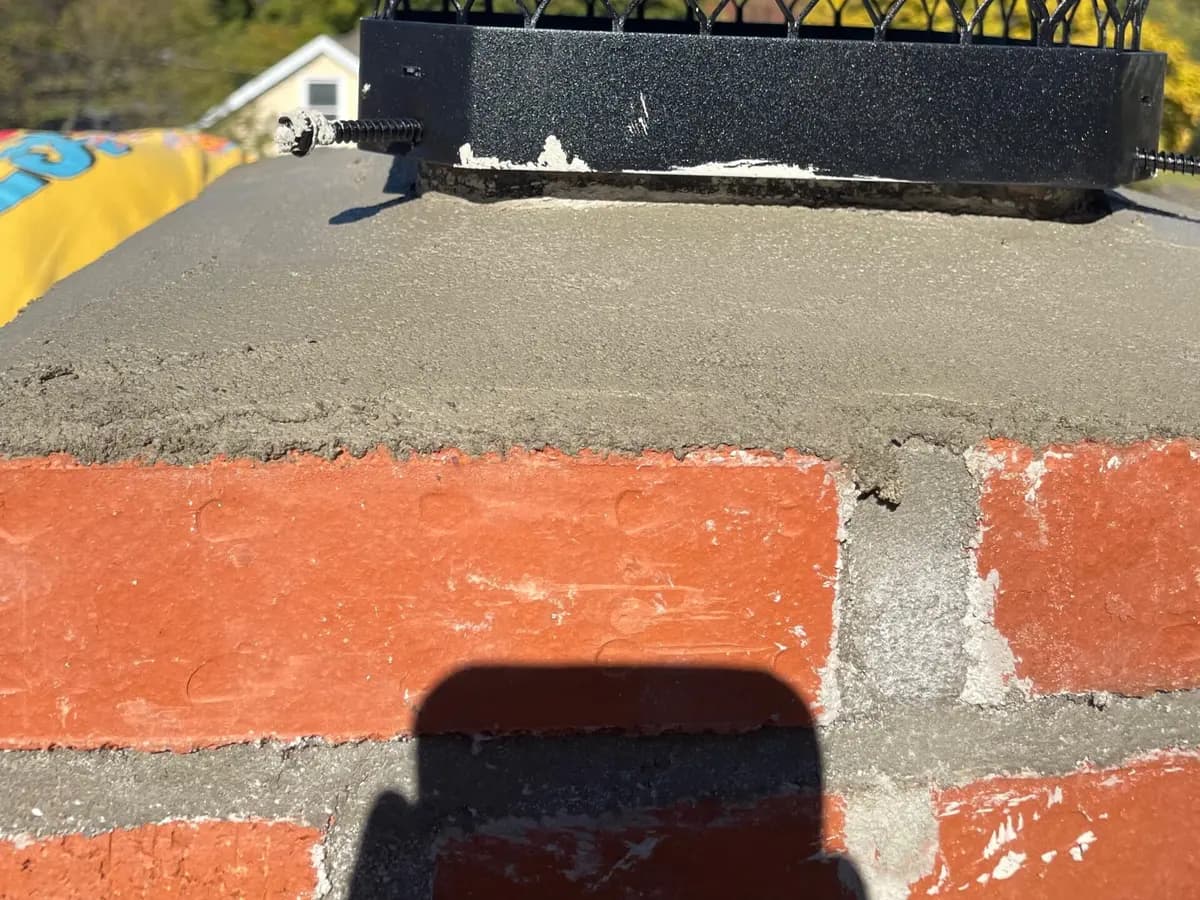 Roofer fitting copper panels along a roof edge against a shingled wall