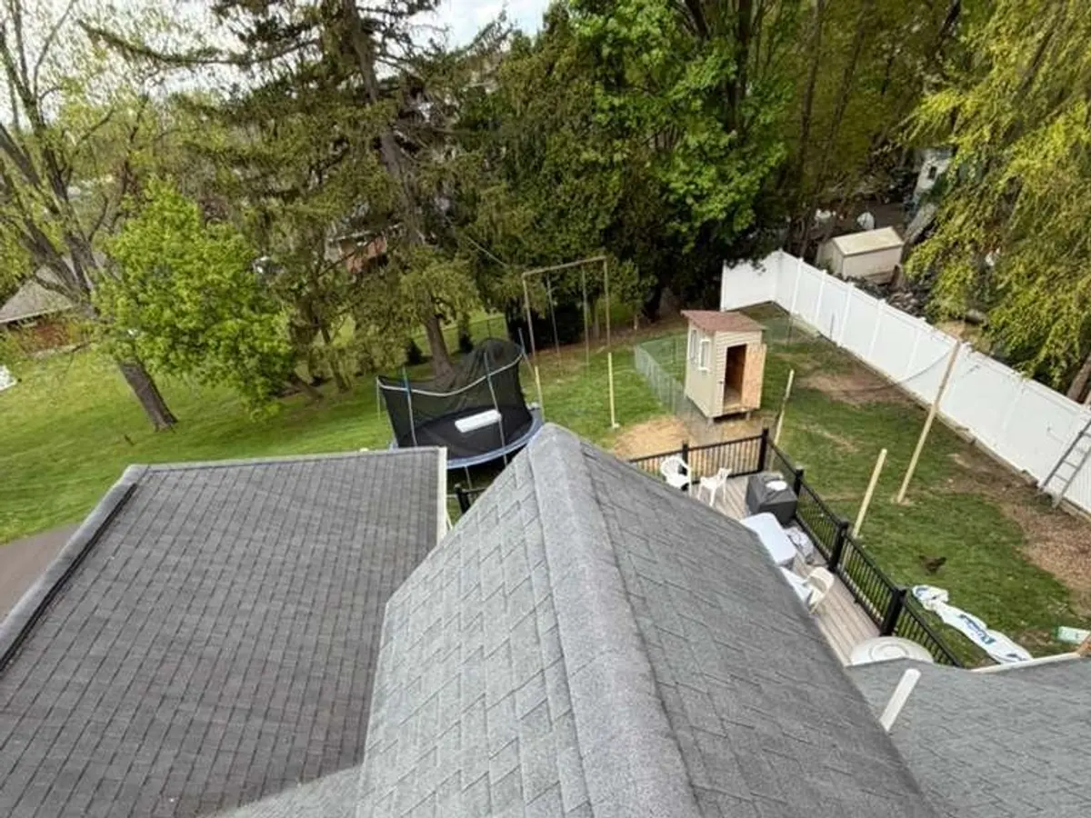 Steep hip roof in grey shingle seen from above after completion