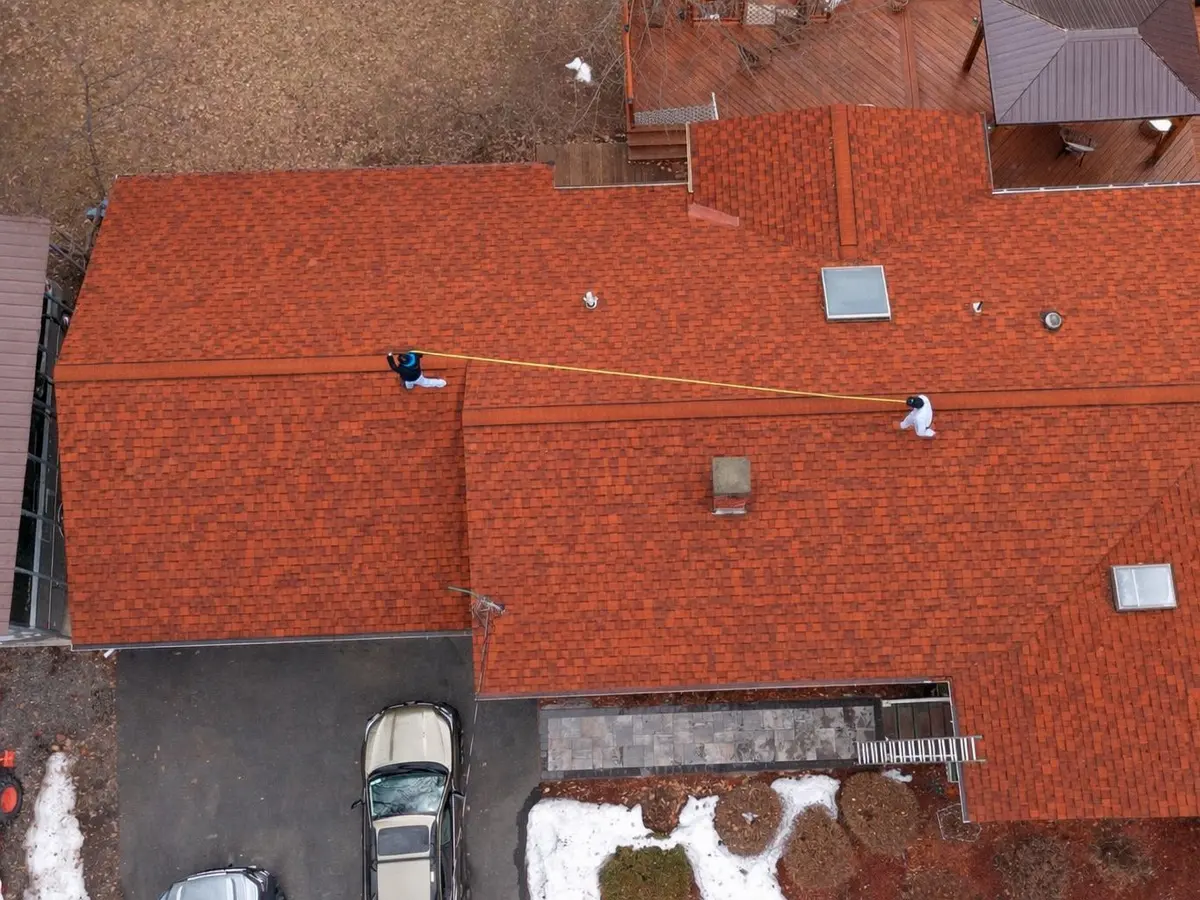 Aerial view of a large terracotta-toned shingle roof after replacement