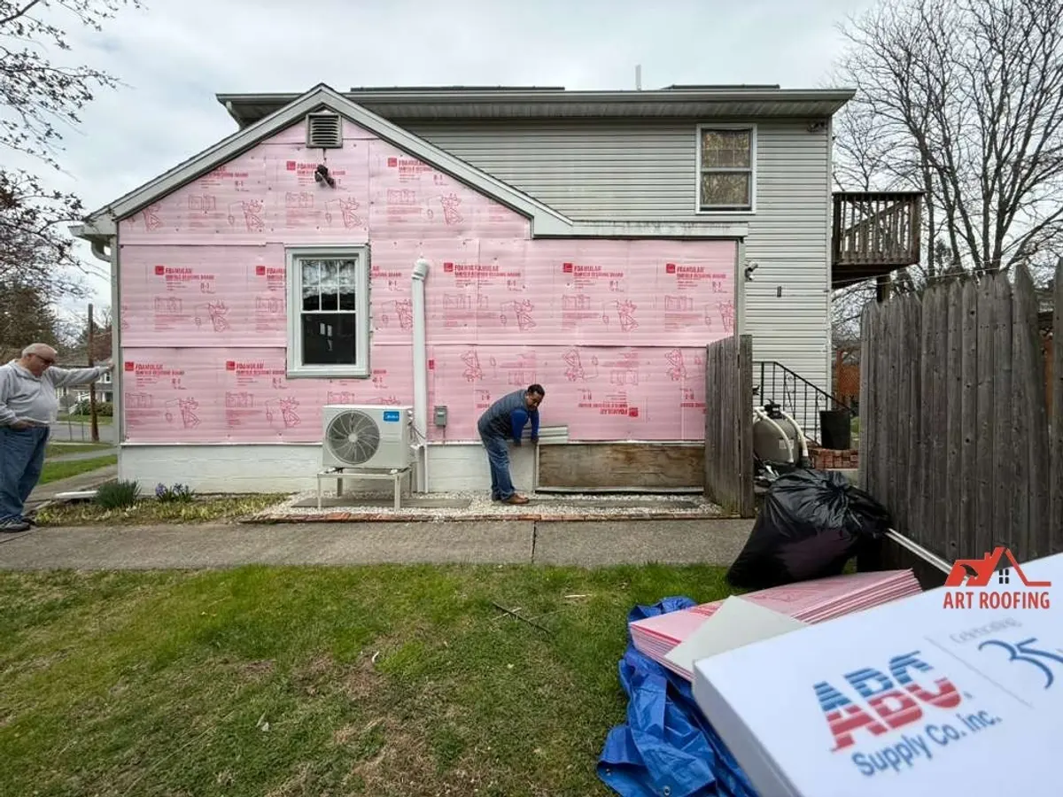 House stripped back to pink insulation board during a siding replacement