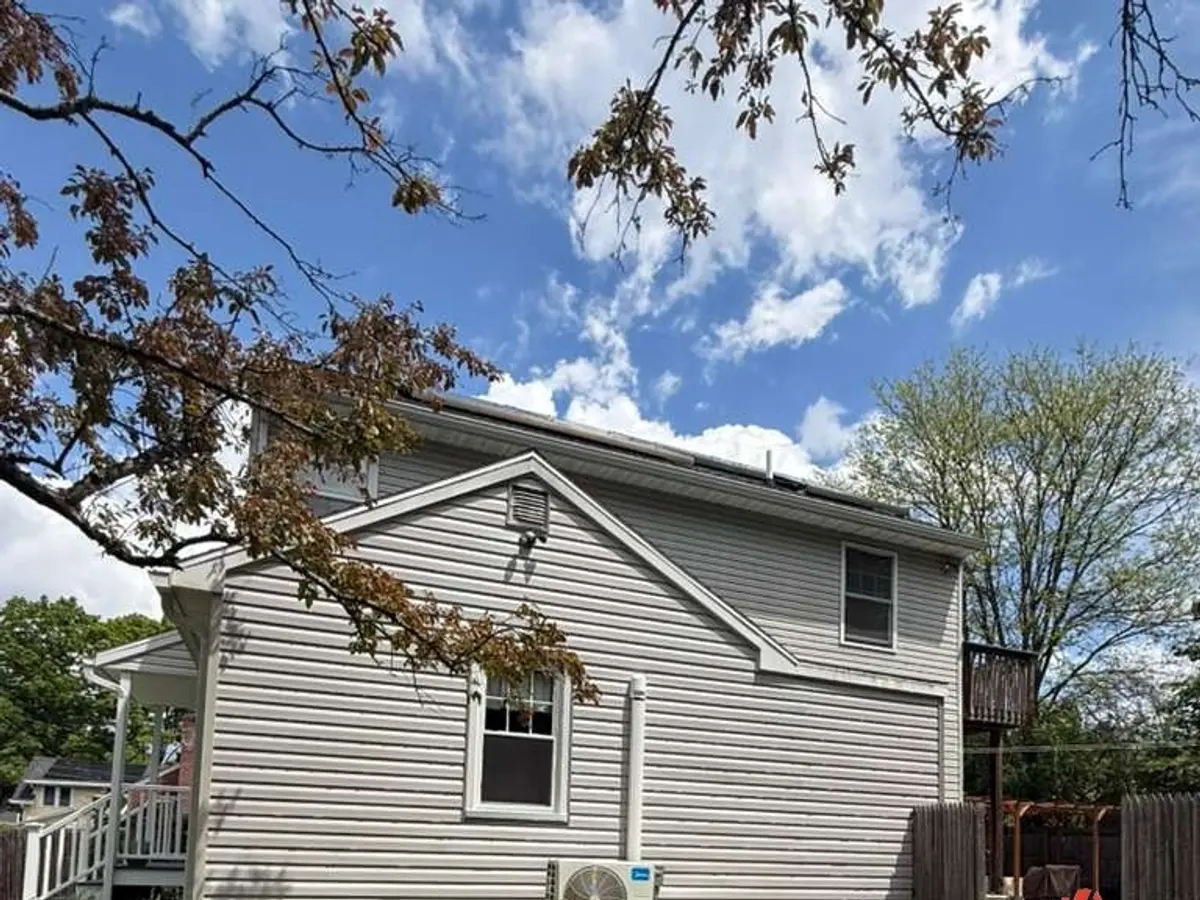 Completed light grey siding on a two-storey home with new trim