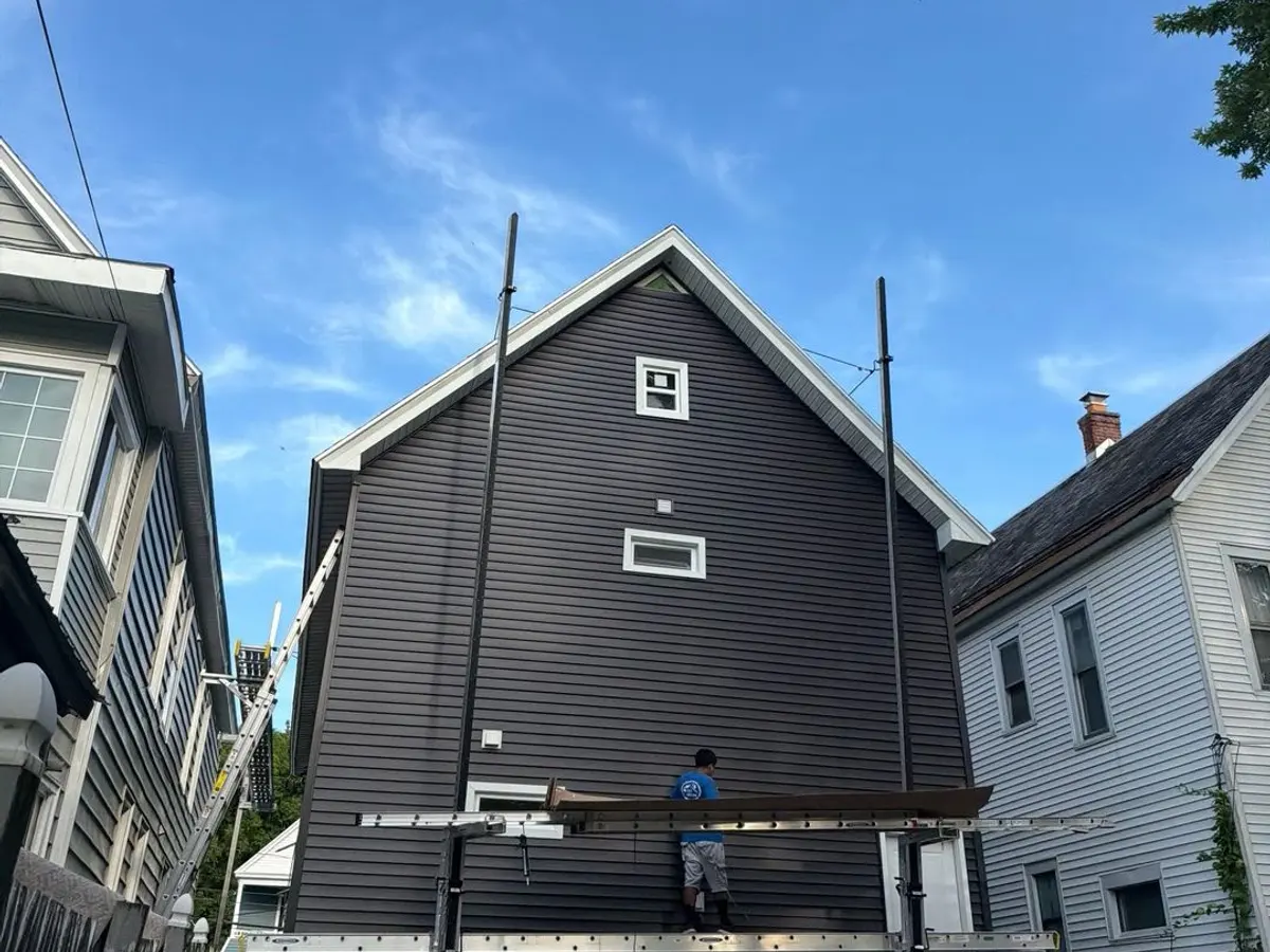 Dark siding and white trim completed on a narrow city home