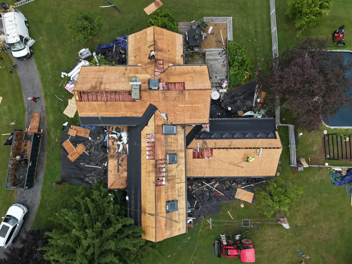 Roof torn back to bare decking across several planes after a storm